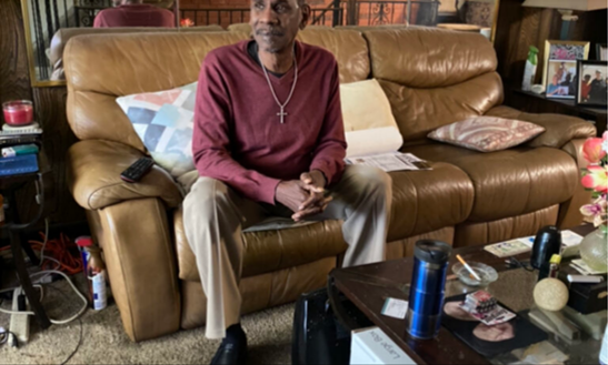 Ed Baker sits in the living room of his home in Philadelphia, Pennsylvania on February 24, 2022. After spending 26 years in prison for a crime he never committed, he had a successful 16 and a half year career as an electrician for the city of Philadelphia. He retired in 2015. [Credit: Bobby Brier]